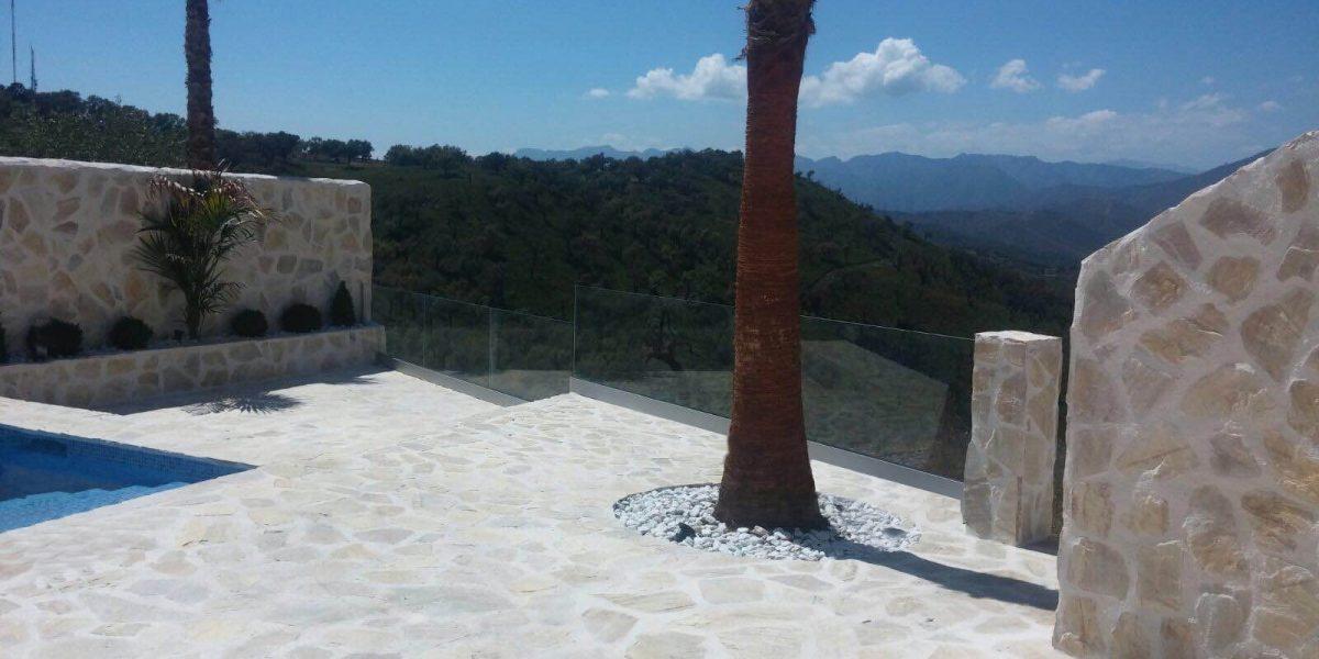 Casa hecha con mármol donde se puede apreciar las barandillas de cristal en el balcón