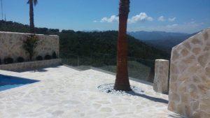 Casa hecha con mármol donde se puede apreciar las barandillas de cristal en el balcón