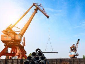 Grúas transportando barrotes de aluminio en un aeropuerto