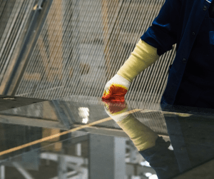 Trabajador poniendo un cristal en una mesa para instalarlo a medida