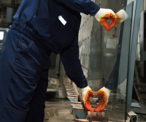 Trabajador intentando transportar un cristal de una mesa para que llegue al lugar sin daños ni golpes