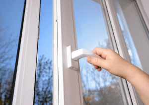 Persona abriendo una puerta de una casa transparente y de aluminio